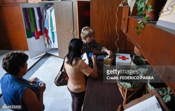 Catholic faithful pays the tithe with a debit card at La Coromoto Church, in Caracas on August 12, 2018. - The shortage of cash in the country has...