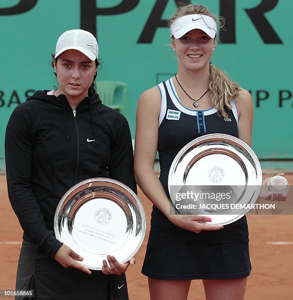 Ons Jabeur of Tunisia holds her runners up trophy as she stands beside winner Elina Svitolina of Ukraine following their Girls Final match in the...