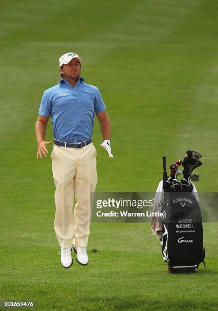 Graeme McDowell of Northern Ireland jumps to see the line of his shot out of the second fairway bunker during the final round of the Celtic Manor...