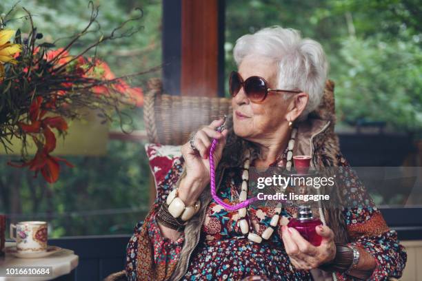 beautiful senior boho stylish woman - hookah stock pictures, royalty-free photos & images