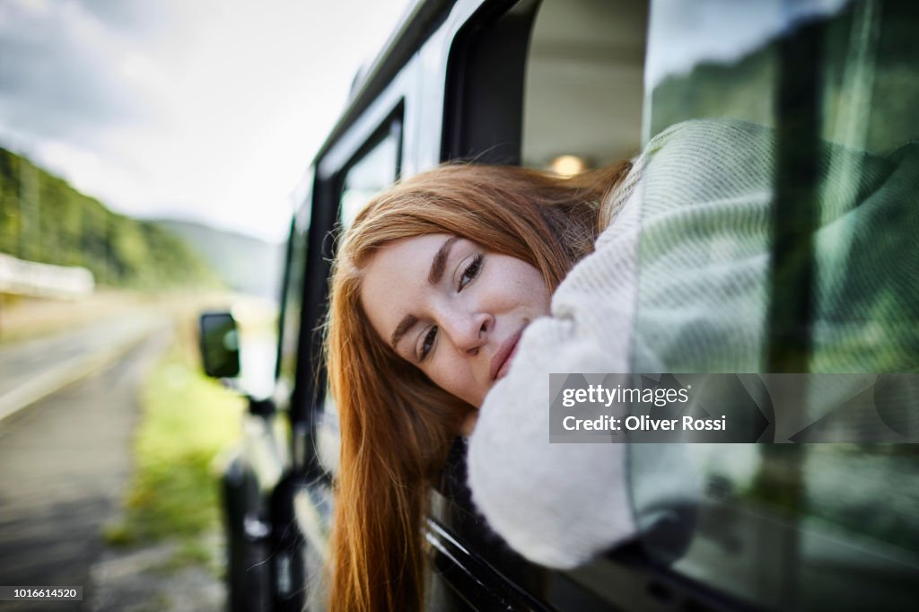 Teenage girl looking out of window of off-road vehicle