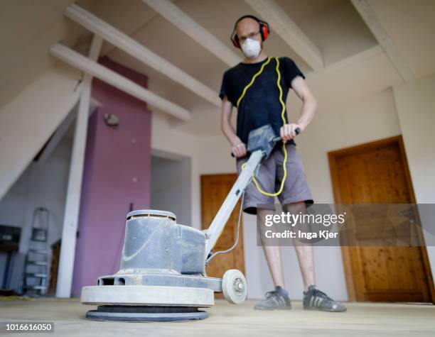 July 24: A craftsman grinds wooden planks with a grinder in an old building apartment on July 24, 2018 in BERLIN, GERMANY.