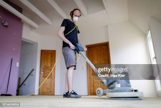 July 24: A craftsman grinds wooden planks with a grinder in an old building apartment on July 24, 2018 in BERLIN, GERMANY.