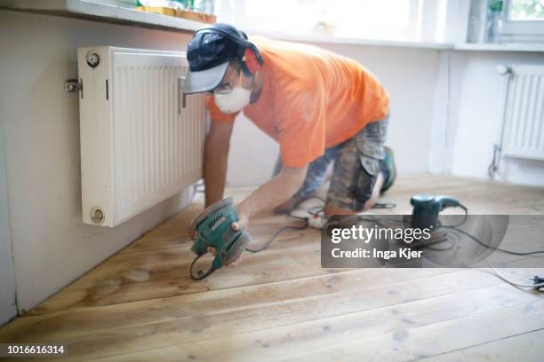 July 24: A craftsman grinds wooden planks with a grinder in an old building apartment on July 24, 2018 in BERLIN, GERMANY.