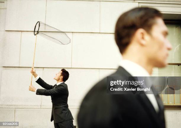 two businessmen, one with butterfly net - butterfly net stock-fotos und bilder