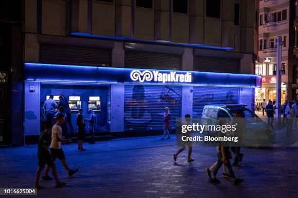 Customers use automated teller machines illuminated at night outside a Yapi ve Kredi Bankasi AS bank branch on Taksim Square in Istanbul, Turkey, on...