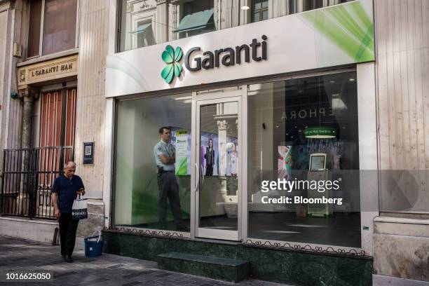 Security guard stands in the window of a Turkiye Garanti Bankasi AS bank branch in Istanbul, Turkey, on Tuesday, Aug. 14, 2018. President Recep...