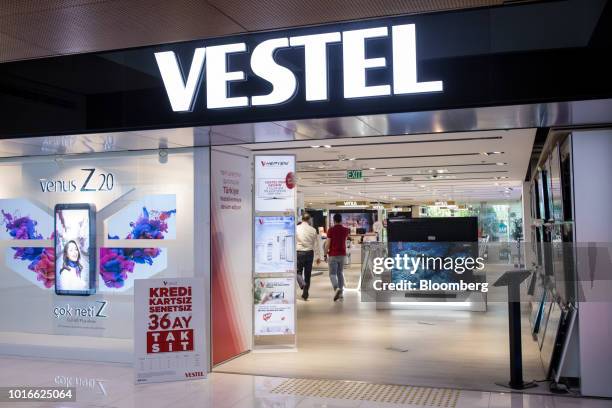 Customers visit a Vestel Elektronik Sanayi ve Ticaret AS consumer electronics store advertising a Venus Z20 smartphone in its window display at the...