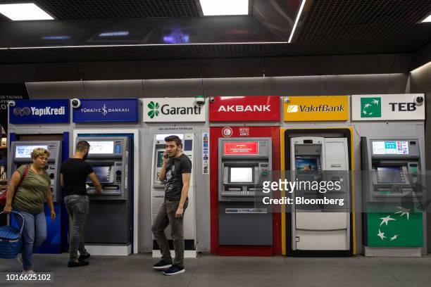Row of automated teller machines operated by, from left, Yapi ve Kredi Bankasi AS, Turkiye Is Bankasi AS, also known as Isbank, Turkiye Garanti...