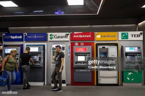 Row of automated teller machines operated by, from left, Yapi ve Kredi Bankasi AS, Turkiye Is Bankasi AS, also known as Isbank, Turkiye Garanti...