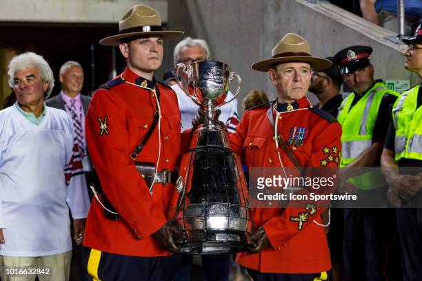 Members of the Royal Canadian Mounted Police hold the Grey Cup Trophy during Canadian Football League action between the Montreal Alouettes and...