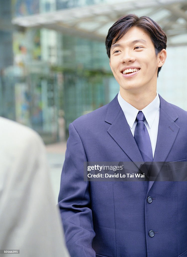 YOUNG BUSINESSMAN SMILING AT CLIENT