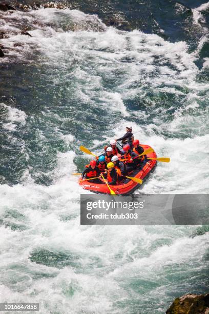 small group of men and women white water river rafting - white water rafting stock pictures, royalty-free photos & images