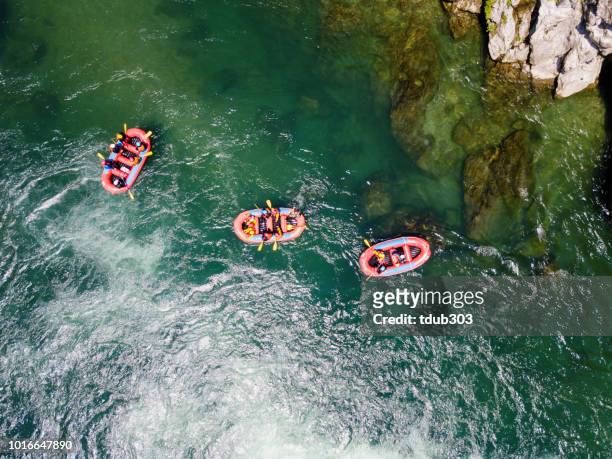 vista aérea de un grupo de hombres y mujeres en varios barcos aguas blancas rafting en el río - bote neumático fotografías e imágenes de stock