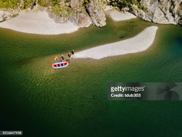 aerial view of a group of men and women exploring an island in a river raft - iya valley stock pictures, royalty-free photos & images