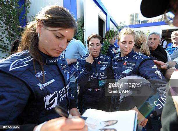 Swiss Cyndie Allemann, Natacha Gaghnang and Rahel Frey, drivers of a Ford GT, sign autographs on June 6, 2010 in Le Mans, western France. Fifty-six...