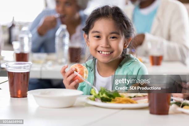 little girl having lunch in soup kitchen - homeless shelter stock pictures, royalty-free photos & images