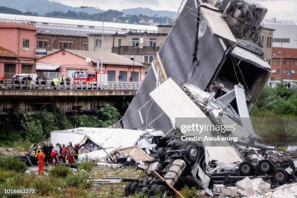 Rescuers work to search for survivors after a section of the Morandi motorway bridge collapsed earlier on August 14, 2018 in Genoa, Italy. At least...