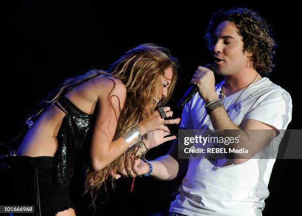 American actress and singer Miley Cyrus and Spanish pop singer David Bisbal perform on stage at the Rock in Rio Madrid music festival on June 6, 2010...