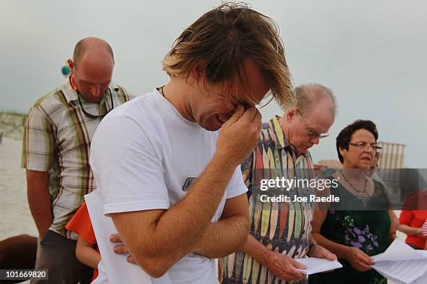Charlie Green is overcome with emotion during a public prayer vigil for the oil spill along Pensacola Beach where oil globs have come ashore as oil...