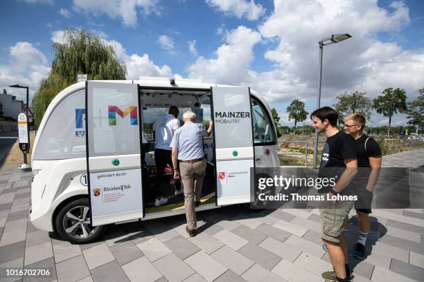 Passengers get in an electric autonomous bus on August 14, 2018 in Mainz, Germany. Called EMMA, the bus is made by Navya and will transport...