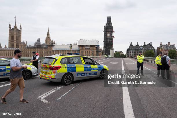 Police officers secure Westminster Bridge going towards the Houses of Parliament after a vehicle crashed into security barriers, injuring a number of...