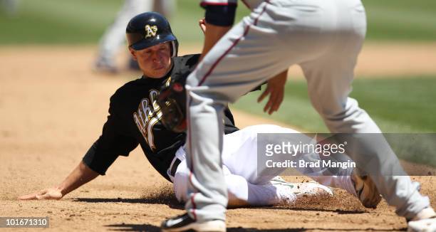 Mark Ellis of the Oakland Athletics slides safely into third base during the game against the Minnesota Twins at the Oakland-Alameda County Coliseum...