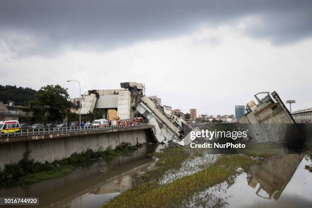 Picture taken on August 14, 2018 shows vehicles standing on a part of a Morandi motorway bridge after a section collapsed earlier in Genoa. - At...