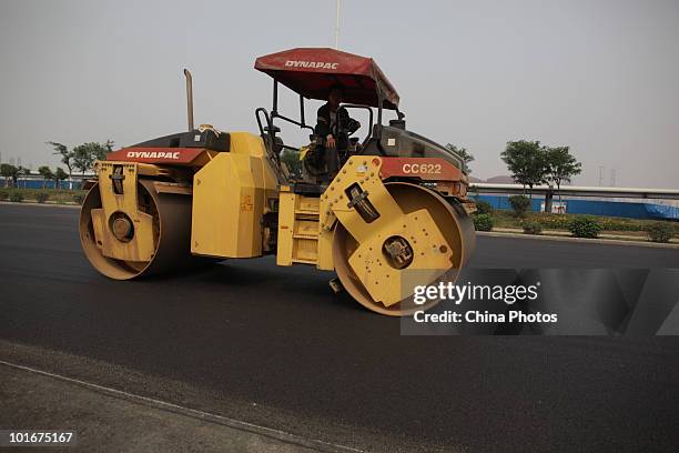 Road roller evens out the ground on land reclamation area at the Tanggu Coastal Economic Zone on June 6, 2010 in Tanggu of Tianjin Municipality,...