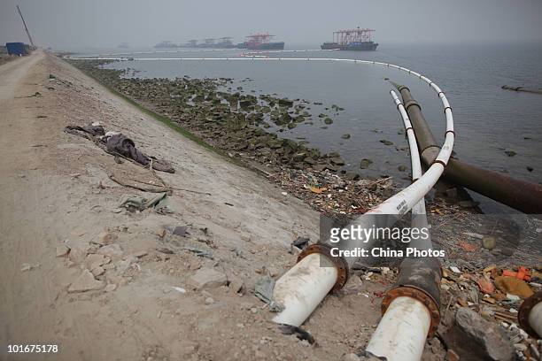Sand carriers transport sand to a land reclamation site through white pipes at the Tanggu Coastal Economic Zone on June 6, 2010 in Tanggu of Tianjin...