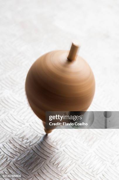 wood spinning top in motion - spinning top stock pictures, royalty-free photos & images