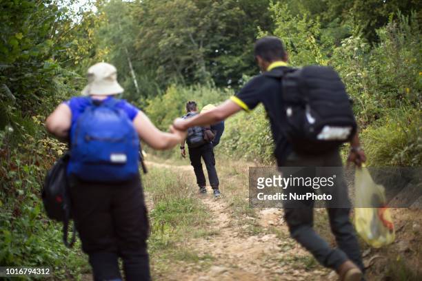 Refugee holds his wife's hand during reaching Croatian border near Velika Kladusa, Bosnia and Herzegovina on August 13, 2018.