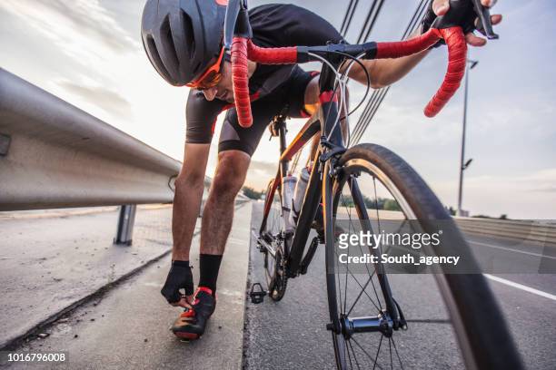 cyclist adjusting gear - triathlon gear stock pictures, royalty-free photos & images