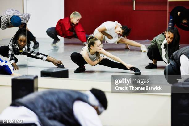 hip hop dance group stretching in dance studio before practice - woman straddling man stock pictures, royalty-free photos & images