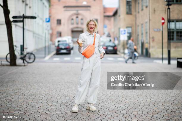 Marianne Theodorsen wearing orange belt bag, white corduroy pants and jacket seen outside Cathrine Hammel during Oslo Runway SS19 on August 14, 2018...