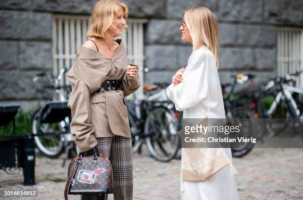 Laura Tonder wearing brown jacket with belt and long oversized sleves, checked pants, Louis Vuitton bag and Celine Aagaard wearing white silk dress...