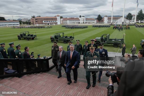 Ivan Duque, Colombia's president, center right, and Guillermo Botero, Colombia's defense minister, center left, arrive for a military ceremony at the...