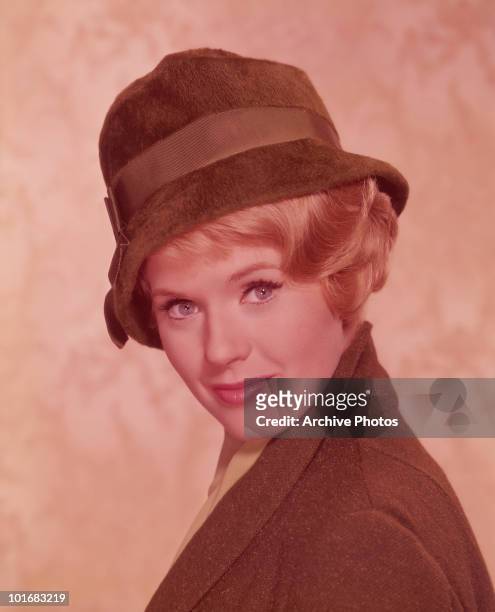 Actress and singer Connie Stevens looking over her shoulder and wearing a brown fur hat and brown tweed jacket, USA, circa 1965.