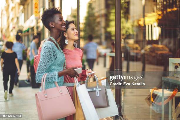 vrienden zijn venster winkelen in de zomer - stylish woman streets europe cellphone stockfoto's en -beelden