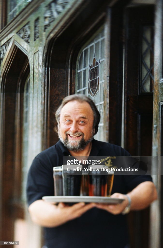 PUB OWNER WITH TRAY OF BEER