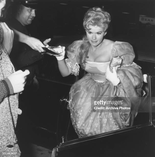 Actress and singer Connie Stevens signing autographs for fans as she arrives at the premiere of 'Sunrise at Campobello', USA, 1960. Stevens is...