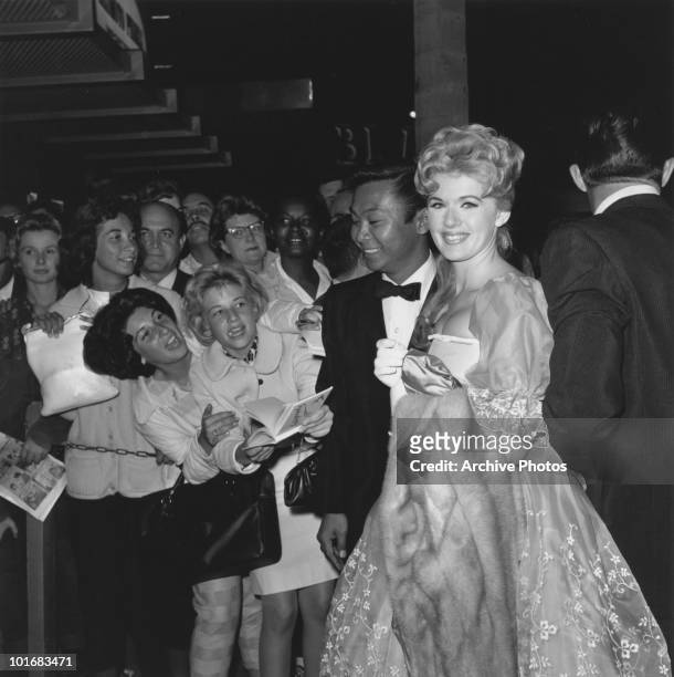 Actress and singer Connie Stevens with Bob Conrad and Poucie Pouce smiling as they meet fans at the premiere of 'Sunrise at Campobello', USA, 1960.