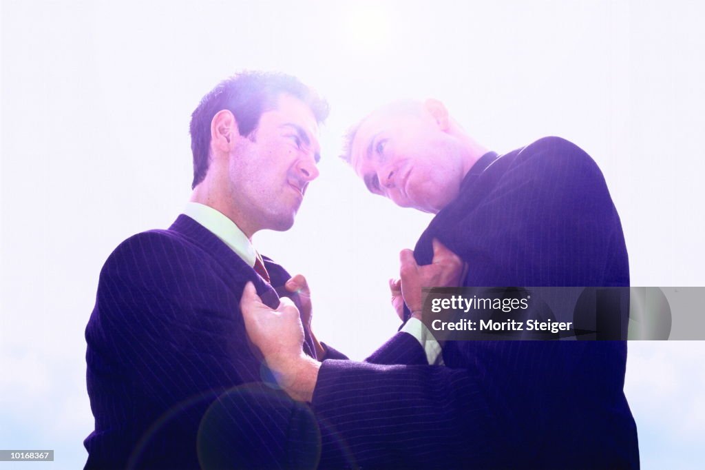 BUSINESSMEN GRABBING EACH OTHER, ARGUING