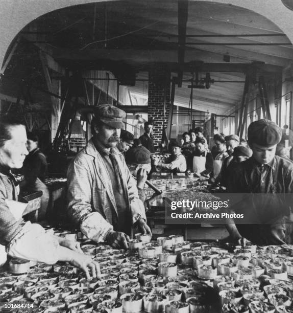 Interior view of the production line at a salmon canning establishment in Astoria, Oregon, USA, circa 1890. Workers are shown packing the individual...