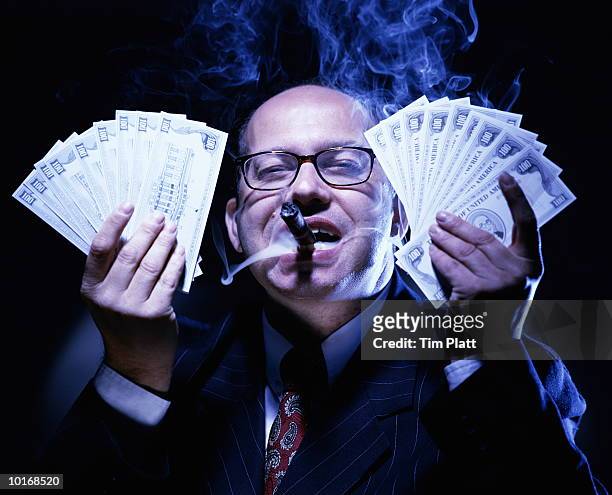 businessman with money, smoking cigar - greed fotografías e imágenes de stock