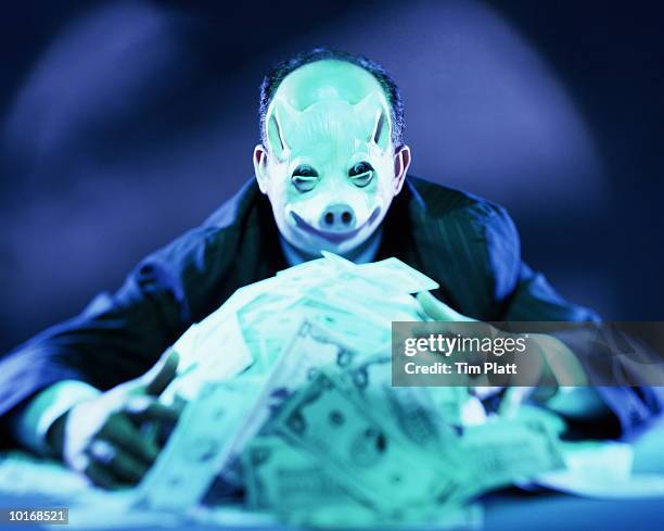 man with pig mask on hoarding money - seven deadly sins stock pictures, royalty-free photos & images