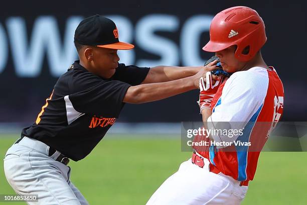 Jurrangelo Cijntje of Netherlands tagged out Omar Riesgo of Cuba during the WBSC U-15 World Cup Group B match between Netherlands and Cuba at Estadio...