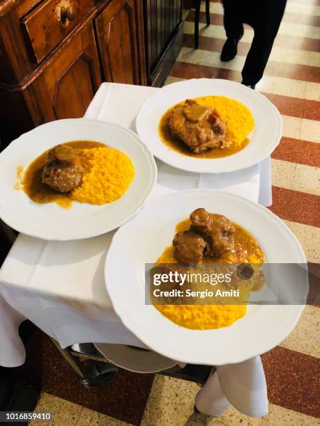 ossobuco con risotto alla milanese - osso bucco stock-fotos und bilder