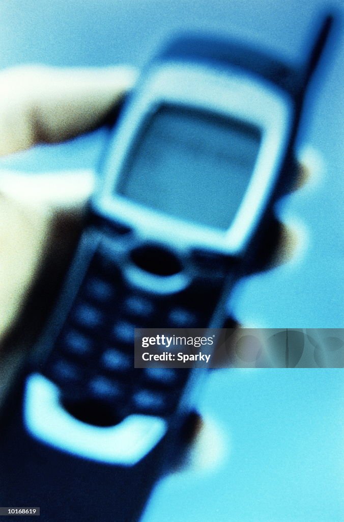 HAND HOLDING MOBILE PHONE