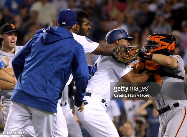 Yasiel Puig of the Los Angeles Dodgers and Nick Hundley of the San Francisco Giants fight as first base coach George Lombard comes between the two...